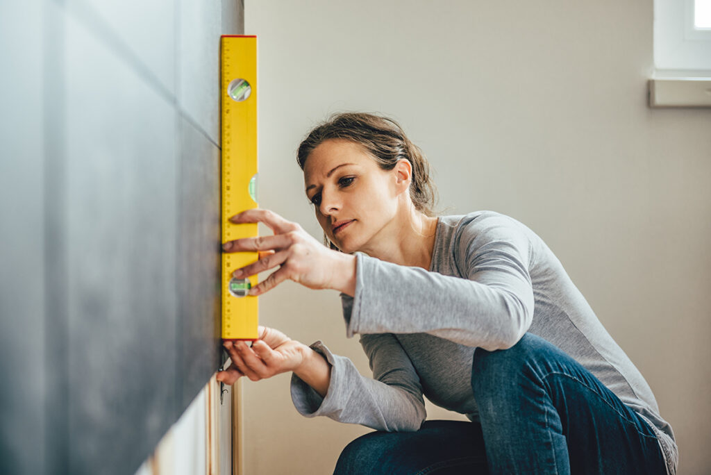 Femme qui prend des mesures pour définir le coût des travaux